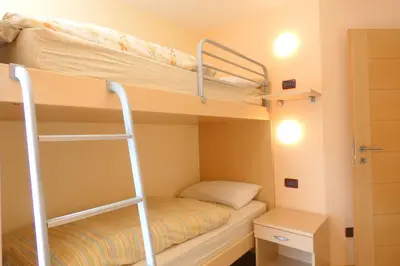 a bunk bed in a room with a ladder at La Meisules in Pozza di Fassa