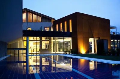 a building with a swimming pool in front of a building at Hotel Grüner Baum in Bressanone