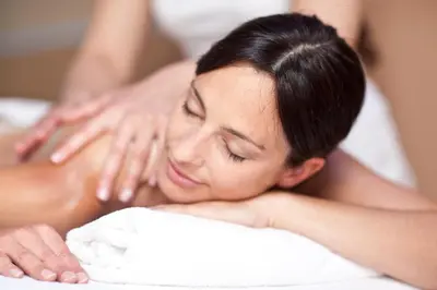 a woman getting a massage in a towel at Hotel Grüner Baum in Bressanone