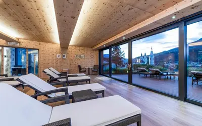 a room with tables and chairs and large windows at Hotel Grüner Baum in Bressanone