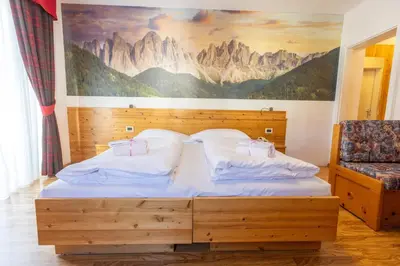 a bedroom with a large bed with a tub at Hotel Rosa Wellness & SPA in Vigo di Fassa