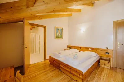 a dining room with tables and chairs and wooden ceilings at Hotel Rosa Wellness & SPA in Vigo di Fassa