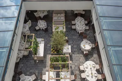 a person preparing plates of food on a table at Hotel Ansitz Plantiz in Merano