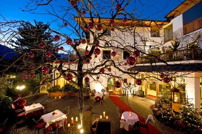 an outdoor patio with tables and chairs and candles at Hotel Ansitz Plantiz in Merano