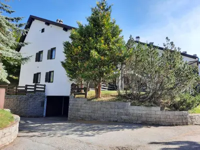 a white house with a tree in front of it at Finestra sul Cermis in Carano