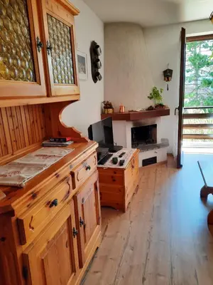 a kitchen with wooden cabinets and a wooden floor at Finestra sul Cermis in Carano