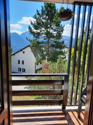 a balcony with a view of a tree and mountains at Finestra sul Cermis in Carano