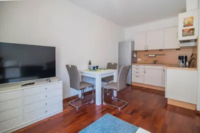 a kitchen with a table and chairs and a tv at RESIDENCE LEONARDO in Merano