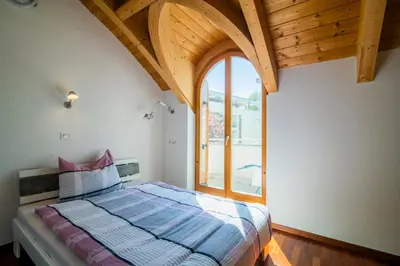 a kitchen with a table with chairs and a large tv at RESIDENCE LEONARDO in Merano