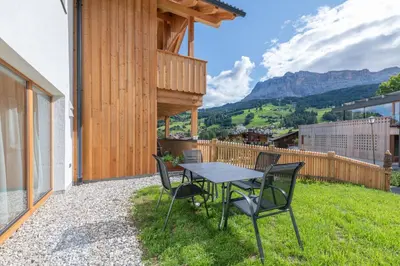 a table and chairs on the patio of a house at Ciasa Nene Franzl in Badia