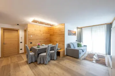 a dining room with a table and chairs and a couch at Ciasa Nene Franzl in Badia
