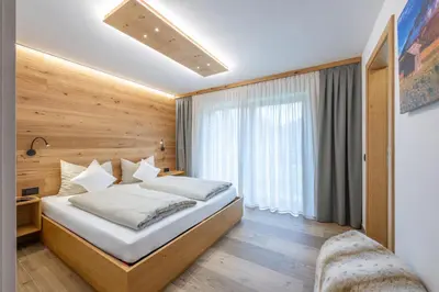 a hotel room with a bed and a window at Ciasa Nene Franzl in Badia