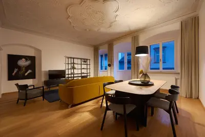 a living room with a yellow couch and a table at Argentieri Apartment in Bolzano