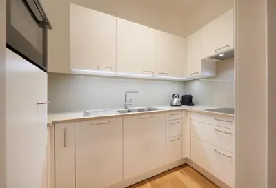 a kitchen with white cabinets and a sink at Argentieri Apartment in Bolzano