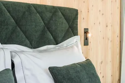 a bedroom with a bed with a green headboard at Amie Chalet in Santa Cristina in Val Gardena