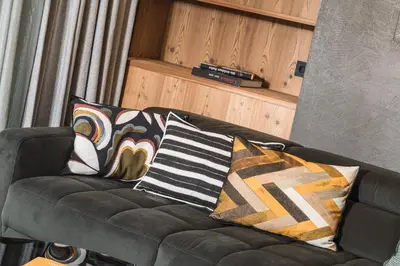 a black couch with pillows on it in a living room at Amie Chalet in Santa Cristina in Val Gardena
