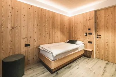 a bedroom with a bed in a wooden wall at Amie Chalet in Santa Cristina in Val Gardena