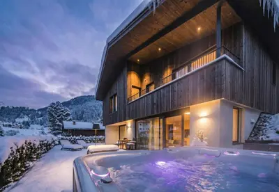 a large building with a hot tub in the snow at Amie Chalet in Santa Cristina in Val Gardena