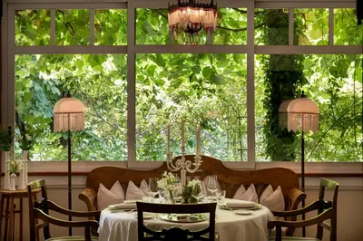 a dining room with a table in front of a window at Relais & Chateaux Hotel Castel Fragsburg in Merano