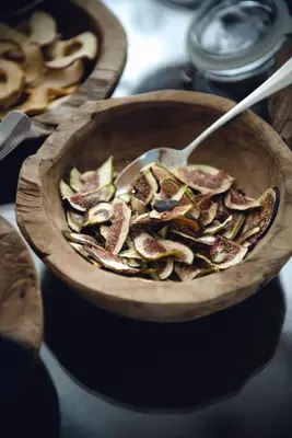 a wooden bowl of food with a spoon in it at Relais & Chateaux Hotel Castel Fragsburg in Merano