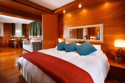 a bedroom with a large bed and a living room at Hotel Mirage in Cortina dʼAmpezzo