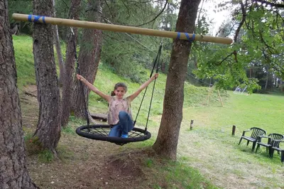 a little girl sitting on a swing in a tree at Hotel Mirage in Cortina dʼAmpezzo