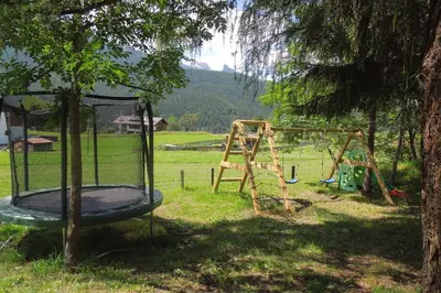 a playground in a park with a tree at Hotel Mirage in Cortina dʼAmpezzo