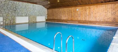 a large swimming pool with blue water in a building at Hotel Mirage in Cortina dʼAmpezzo