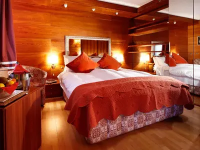 a bedroom with a large bed and wooden walls at Hotel Mirage in Cortina dʼAmpezzo