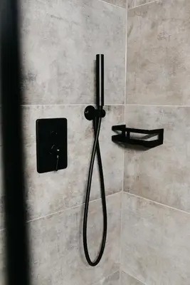 a shower with a hose in a bathroom stall at Nepomuk rooms in Vipiteno