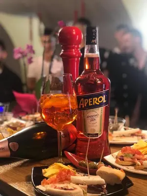 a bottle of alcohol and a glass of wine on a table at Green Apartment in Bolzano