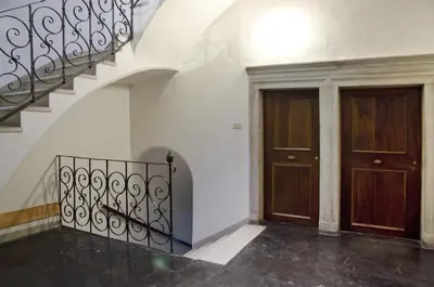 a hallway with two wooden doors and a staircase at Green Apartment in Bolzano