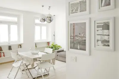 a white dining room with a white table and chairs at Green Apartment in Bolzano