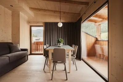 a kitchen and living room with a table and a couch at Villa Melitta in San Vigilio Di Marebbe