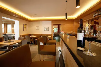 a restaurant with a bar with a bottle of wine at Gasthof Weber in Petersberg