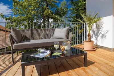 a patio with a couch and a table on a deck at Gasthof Weber in Petersberg
