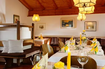 a restaurant with tables and chairs and a chandelier at Gasthof Weber in Petersberg