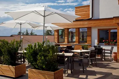 a patio with tables and chairs and an umbrella at Gasthof Weber in Petersberg