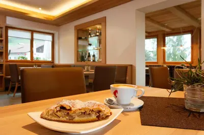 a table with a plate of pastry and a cup of coffee at Gasthof Weber in Petersberg