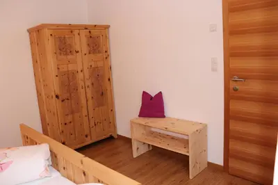 a bedroom with a bed and a wooden cabinet at Schneiderhof in Valdurna