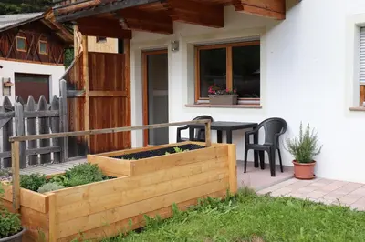 a wooden deck with a table and chairs on a house at Schneiderhof in Valdurna