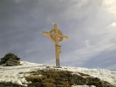 a wooden cross on top of a snow covered hill at Schneiderhof in Valdurna