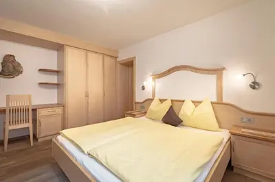 a bedroom with a large white bed with yellow pillows at Apartments Soval in Santa Cristina in Val Gardena