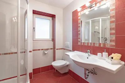 a bathroom with a sink and a toilet and a mirror at Apartments Soval in Santa Cristina in Val Gardena