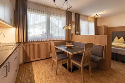 a kitchen with a table and chairs and a bed at Apartment Ruiel in Santa Cristina in Val Gardena