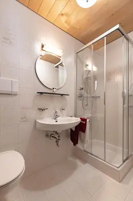 a bathroom with a shower and a sink and a mirror at Apartment Ruiel in Santa Cristina in Val Gardena