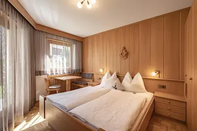 a hotel room with a bed and a table at Apartment Ruiel in Santa Cristina in Val Gardena