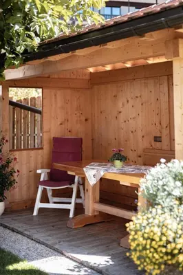 a wooden shed with a table and two chairs at Apartment Ruiel in Santa Cristina in Val Gardena