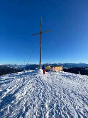 a person standing on top of a snow covered hill with a cross at Villa Silvia in Naz-Sciaves