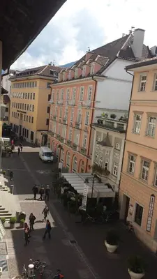 a group of people walking down a street with buildings at Argentieri Guesthouse in Bolzano